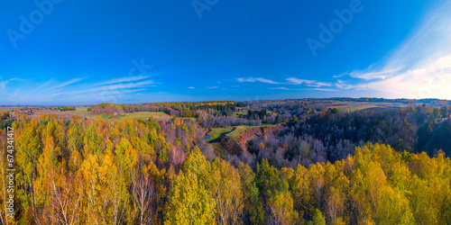 Colorful autumn forest form above, captured with a drone. Bradeliškiai mound. Natural seasonal landscape background. © lukjonis