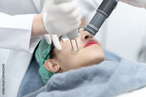 Woman receiving pico laser facial treatment in beauty Clinic. photo