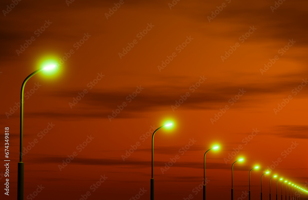 Street lighting poles against the sky in the colors of sunset.