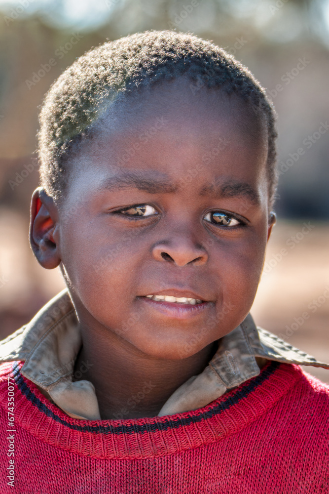 close portrait headshot of an african child portrait , outdoors day light village in africa close portrait headshot of an african child portrait , outdoors day light village in africa