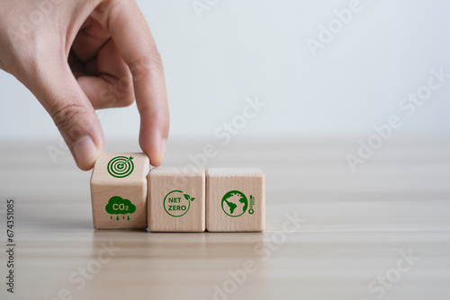 Hand flipping wooden block icon CO2 and target to carbon-neutral for net zero emission. green economy and sustainable environment for the future.Clean Energy and ESG Concept
