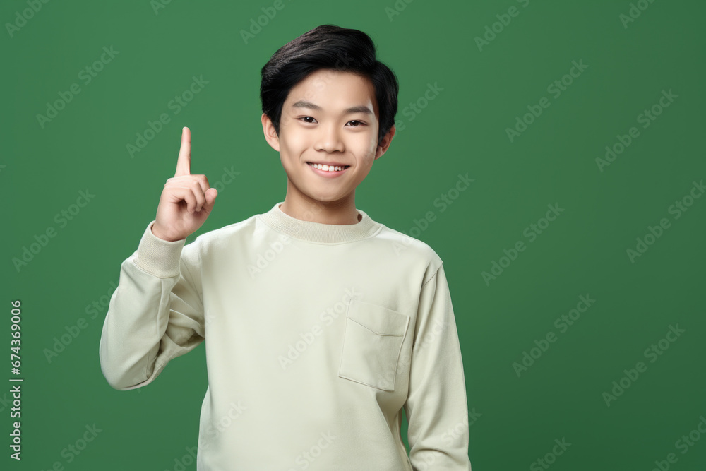 Young man confidently holds his finger up in air, signaling something important. This image can be used to represent concepts such as success, direction, leadership, or making point. Young man confidently holds his finger up in air, signaling something important. This image can be used to represent concepts such as success, direction, leadership, or making point.