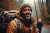 Man with backpack smiles as he walks down path. Suitable for travel, adventure, and outdoor lifestyle themes.