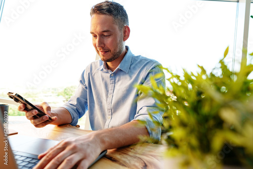 Young businessman working in office with laptop and smartphone