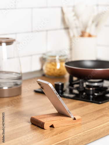 Smartphone in a wooden stand on the table.