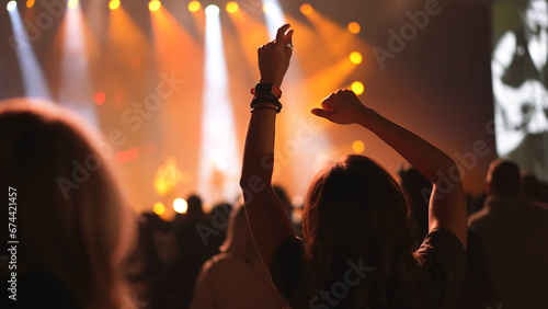 Happy woman enjoy cool live music concert. Fun girl hang out disco dj party. Many joy young adult people chill k pop fest. Neon rock night rave. Dancer crowd. A lot of fans raise hand up. Dance floor.