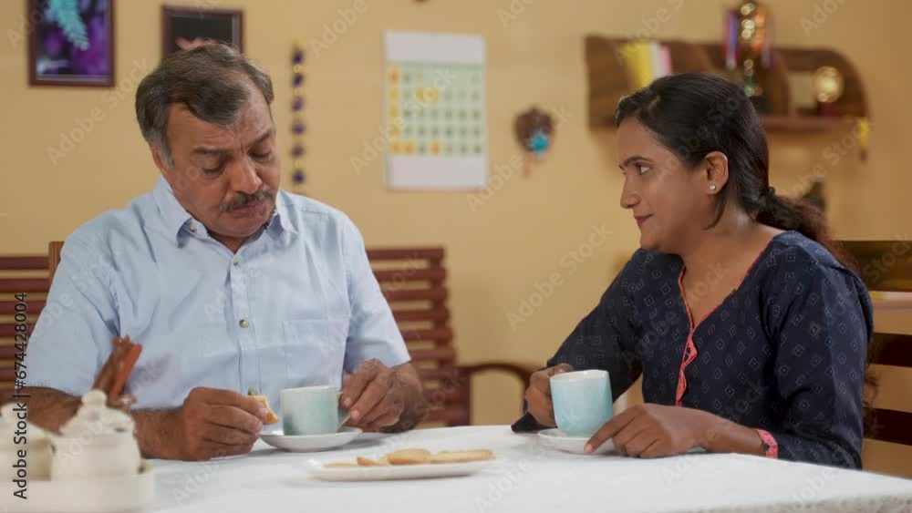 Happy Indian father with daughter spending time together while having morning tea or coffee at home - concept of family time, relationship bonding and companionship. Happy Indian father with daughter spending time together while having morning tea or coffee at home - concept of family time, relationship bonding and companionship.