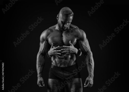 Perfect abdomen. Female hands embracing, touching muscular man abs isolated over black background. Sports, workout, bodybuilding concept.