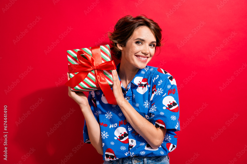 Portrait of cute cheerful girl toothy smile hands hold desirable newyear giftbox isolated on red color background Portrait of cute cheerful girl toothy smile hands hold desirable newyear giftbox isolated on red color background