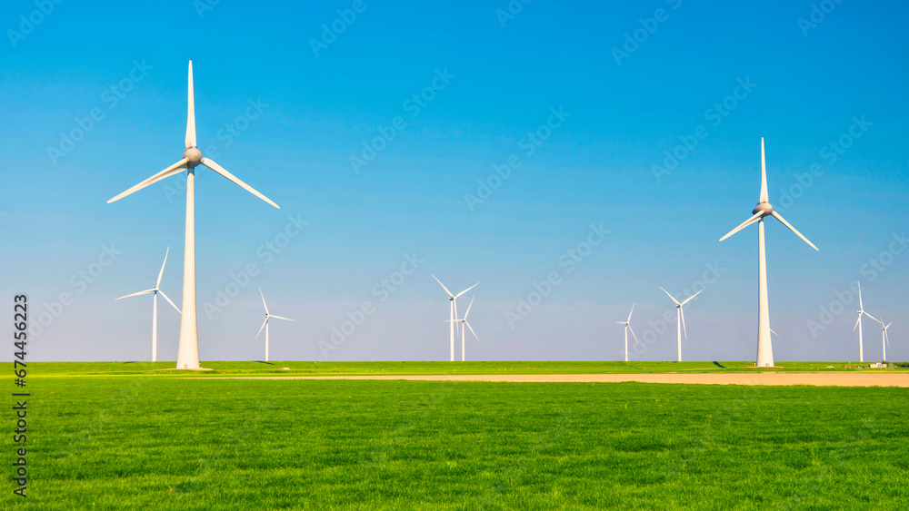 Windmill turbines in the Netherlands, wind mill turbines with a green meadow in front Windmill turbines in the Netherlands, wind mill turbines with a green meadow in front