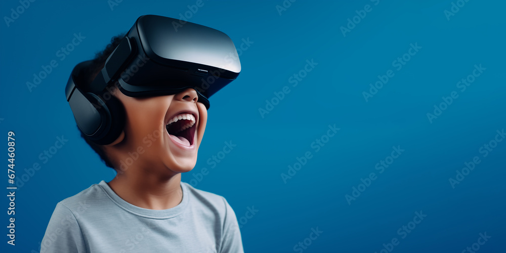 Young boy getting experience using VR headset glasses isolated on a blue background with copy space Young boy getting experience using VR headset glasses isolated on a blue background with copy space