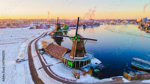 Zaanse Schans Netherlands a Dutch windmill village during sunrise at winter with a snowy landscape, winter snow at the historical windmill village near Amsterdam during sunrise photo