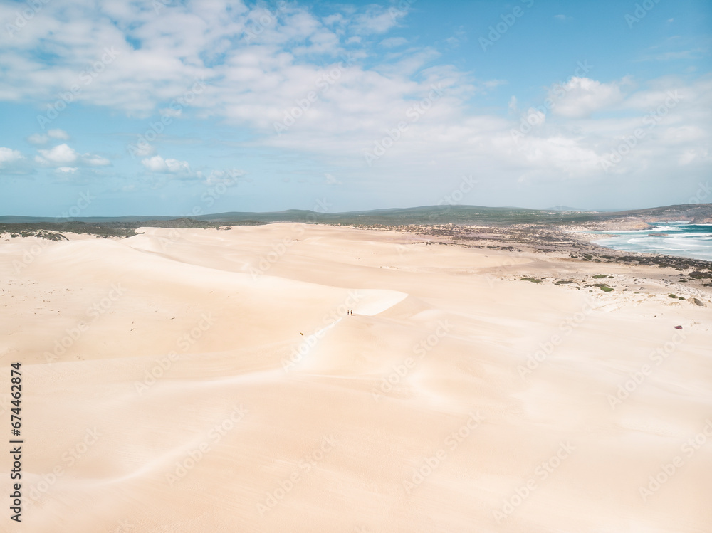 Aerial view of a desert landscape with two people standing on a sand dunes in Port Lincoln National Park , South Australia. Aerial view of a desert landscape with two people standing on a sand dunes in Port Lincoln National Park , South Australia.