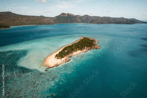Aerial view of Black Island with the reef stretching far out and Hook Island visible in the distance, Whitsundays, Australia. photo