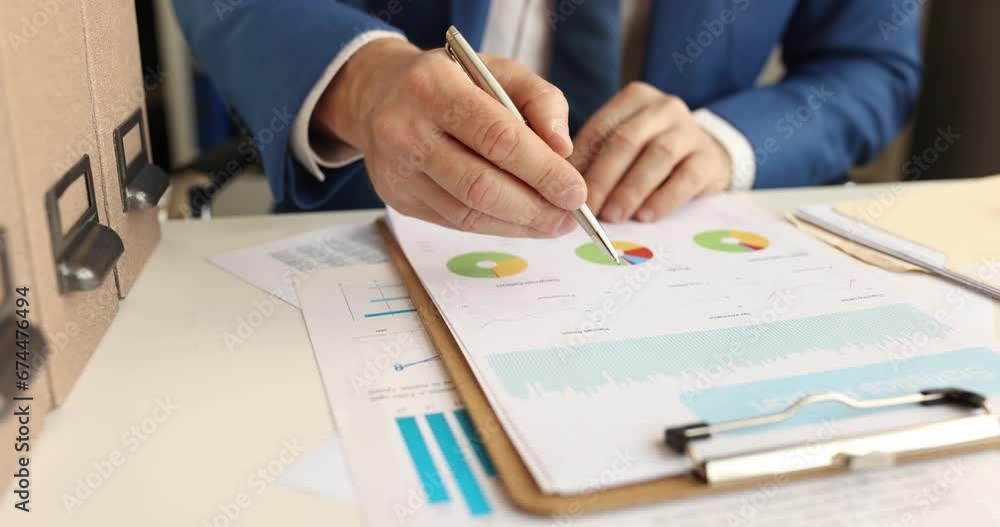 Businessman studies financial report and puts signature. Small and medium business development concept Businessman studies financial report and puts signature. Small and medium business development concept