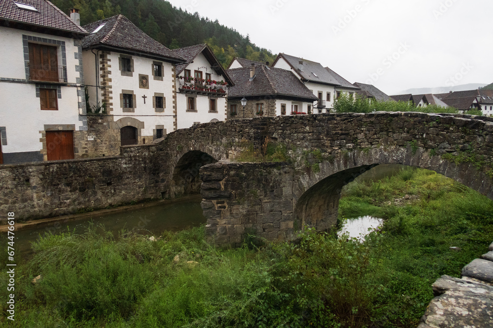 Vista del pueblo Ochagavía y sus casas típicas desde el puente de piedra medieval, selva de Irati, Navarra, España.