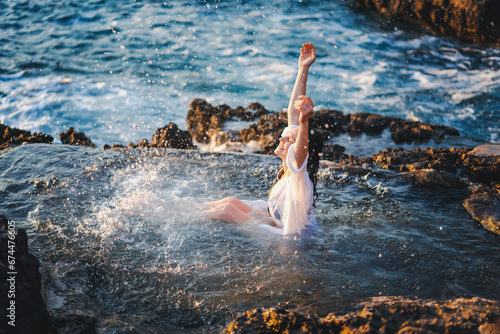 Young cheerful relaxed woman in a white shirt in a natural sea bath on the seashore. Thalassotherapy wellness concept photo