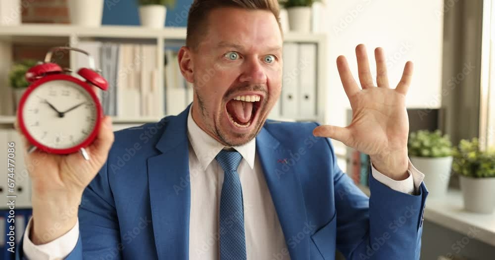 Young businessman looks at the alarm clock and shouts. Time management and deadline concept Young businessman looks at the alarm clock and shouts. Time management and deadline concept