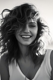 Woman with smile on her face and hair blowing in the wind.