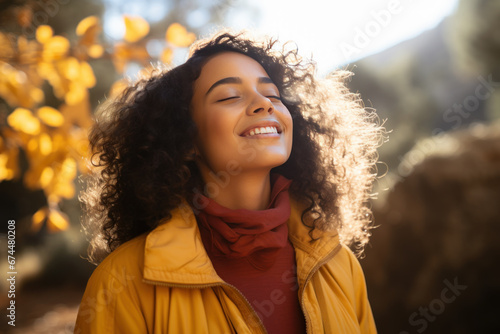 A latin woman breathes calmly looking up enjoying autumn air