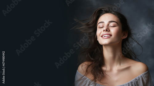 A brunette woman breathes calmly looking up isolated on gray background