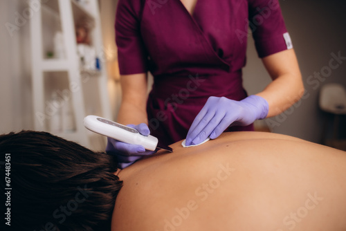 ultrasonic cleaning of a man's back in a beauty salon photo