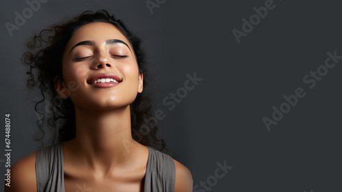 A Indian woman breathing calmly looking up isolated on gray background