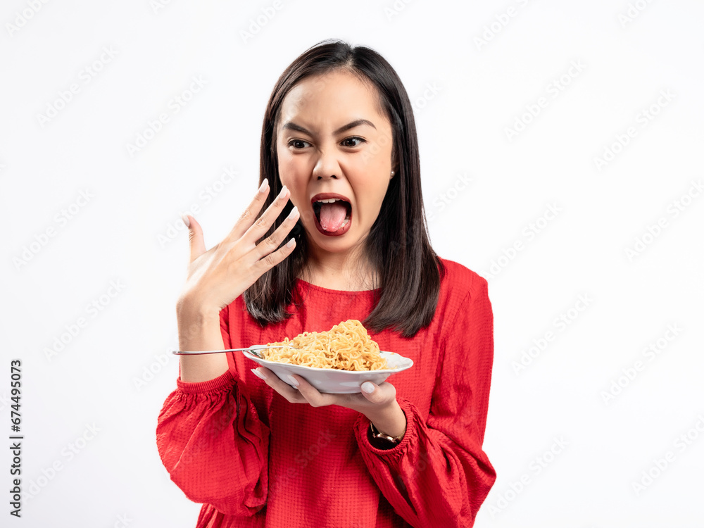 A portrait of a happy Asian woman wearing a red shirt, eating noodles, and feeling a bit spicy. Isolated against a white background. A portrait of a happy Asian woman wearing a red shirt, eating noodles, and feeling a bit spicy. Isolated against a white background.