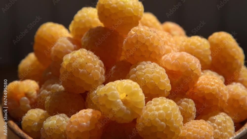 Yellow raspberries in a wooden bowl on the table. Summer berries background. Vitamin food, berry harvest. Healthy nutrition. Yellow raspberries in a wooden bowl on the table. Summer berries background. Vitamin food, berry harvest. Healthy nutrition.