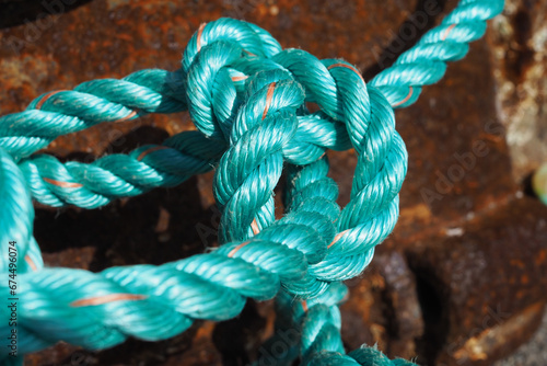 Foto Close up of bright turquoise green/blue braided fishing rope on quayside in fish