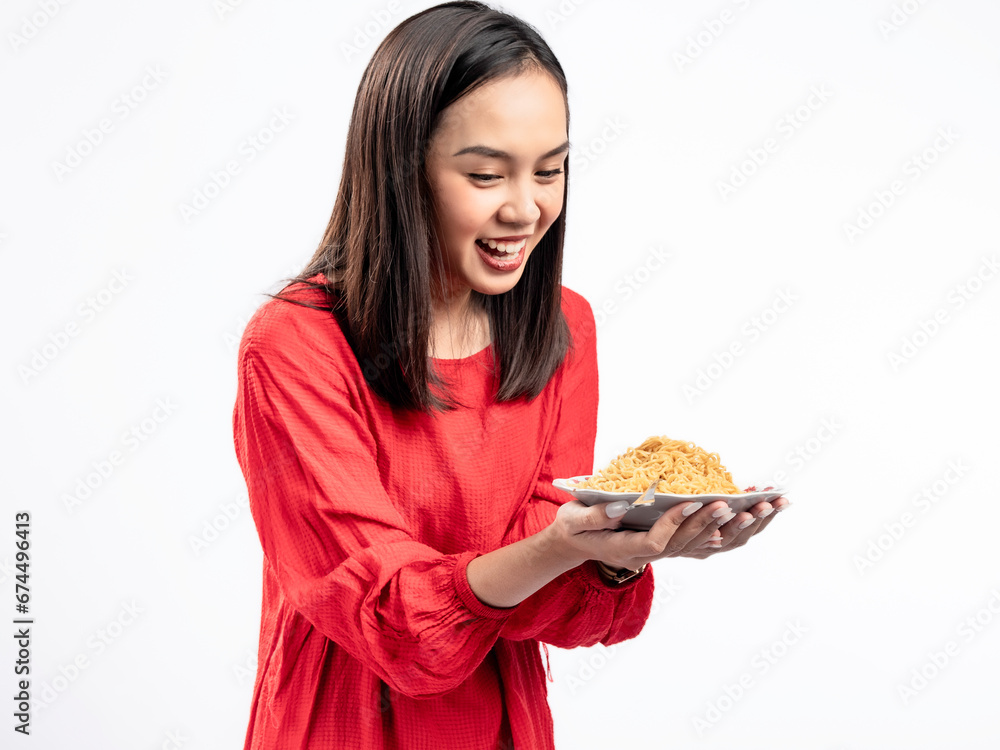 A portrait of a happy Asian woman wearing a red shirt, presenting noodles, and about to eat them. Isolated against a white background. A portrait of a happy Asian woman wearing a red shirt, presenting noodles, and about to eat them. Isolated against a white background.