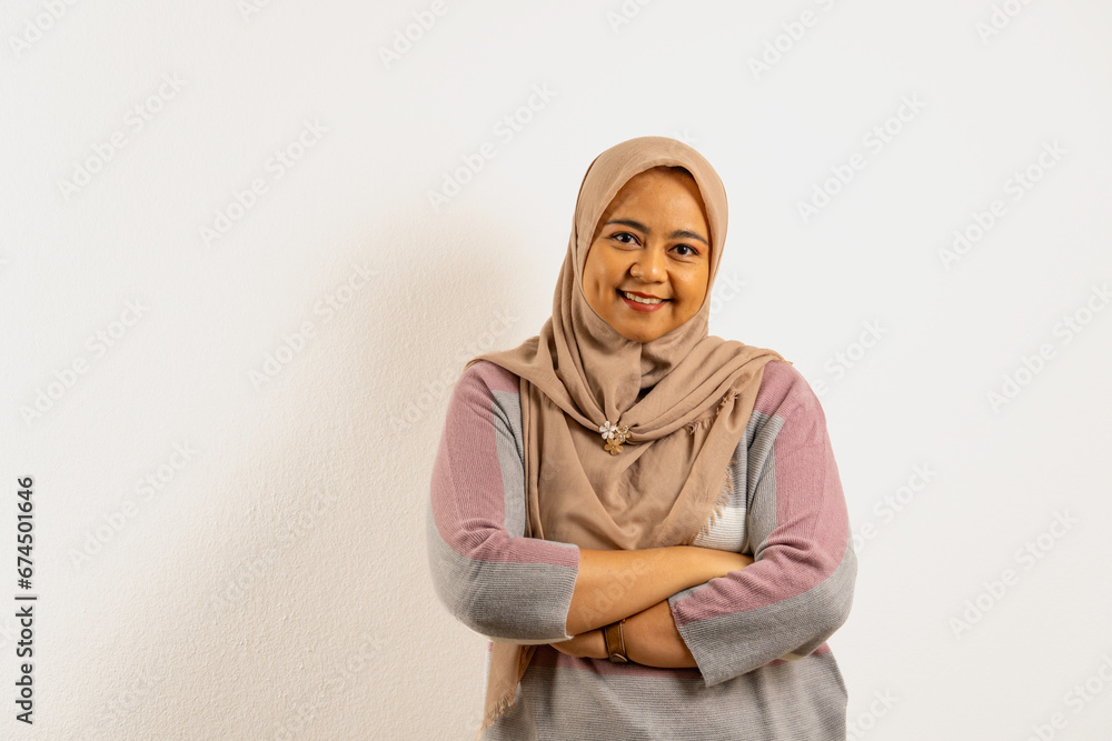 Asian Muslim woman with dimple, wearing hijab or headscarf smiling at the camera. Indonesian woman on white background. Asian Muslim woman with dimple, wearing hijab or headscarf smiling at the camera. Indonesian woman on white background.