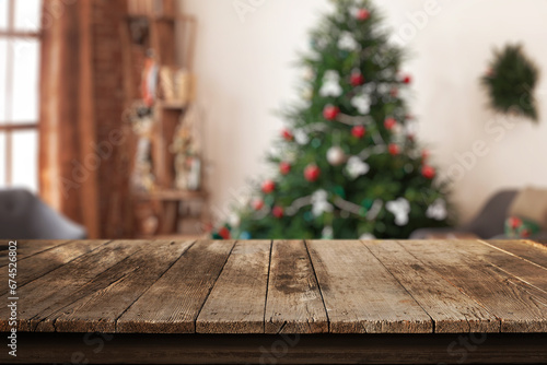 Wooden desk in a home living room with a Christmas tree and festive decorations in the background. Perfect setting for a warm and inviting holiday atmosphere