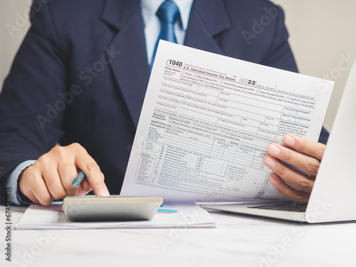 Hand holding of form 1040. U.S. individual income tax return while sitting at the table in the office