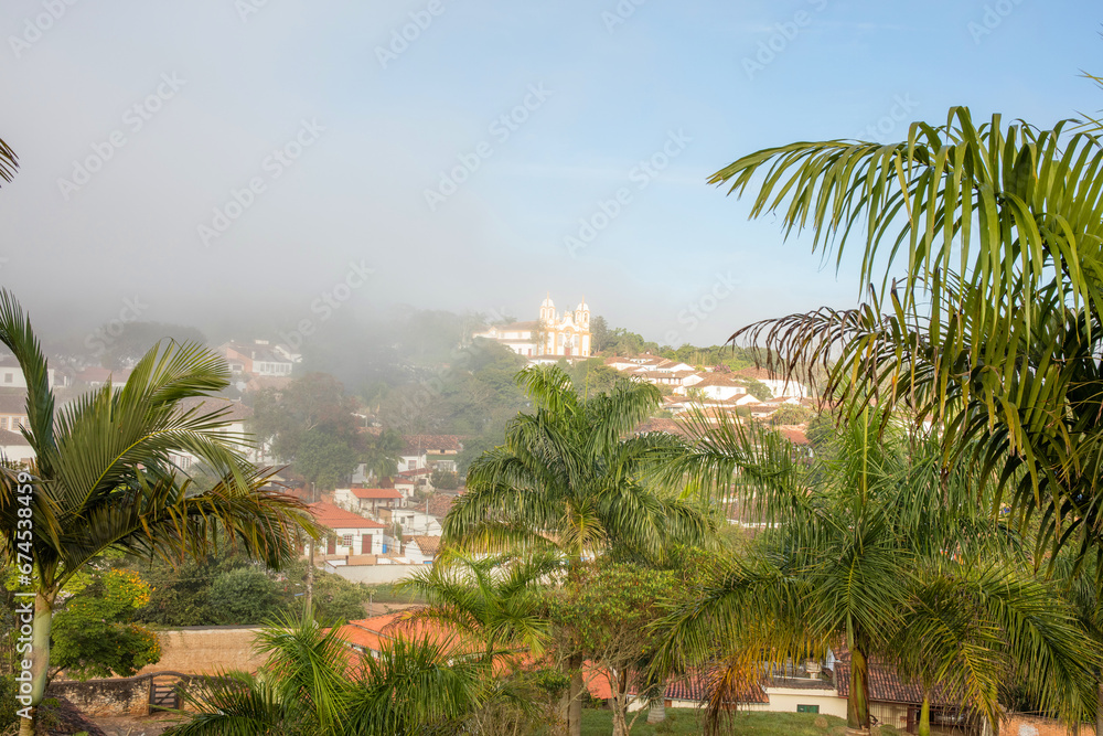 Aerial view of the city of Tiradentes with low fog, with mountains in the background