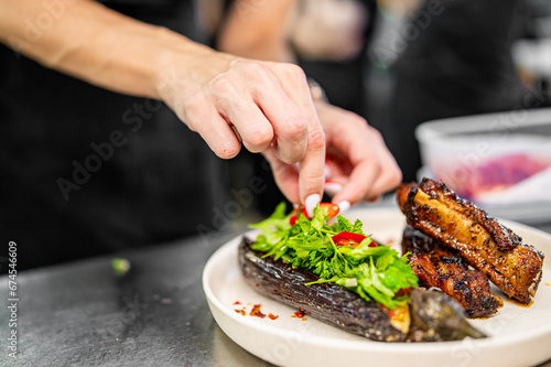 chef Cooking of grilled pork ribs with baked eggplant at the restaurant kitchen