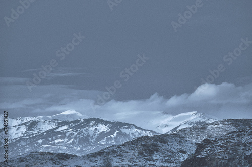 Cold snowy mountain landscape at sunset. Panoramic view of snowy mountain peaks and slopes of North Chuyskiy ridge at sunset. Russia, Siberia, Altai mountains.  photo