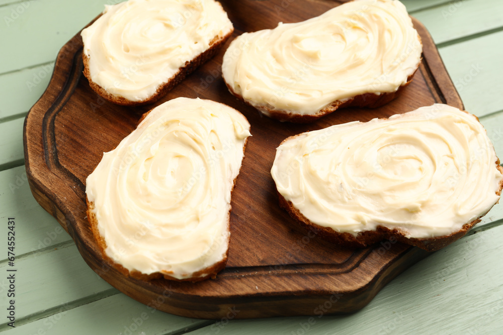 Wooden board of tasty sandwiches with cream cheese on green wooden background Wooden board of tasty sandwiches with cream cheese on green wooden background