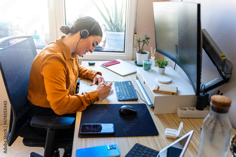Computer programmer working from home. Teleworking concept. Business woman taking notes. Computer programmer working from home. Teleworking concept. Business woman taking notes.