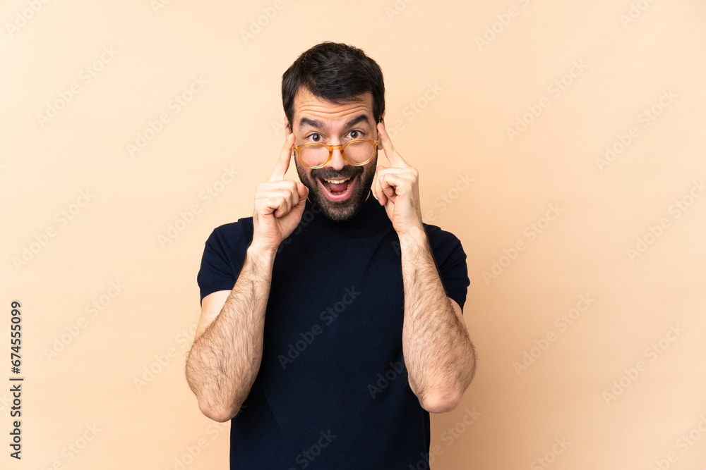 Caucasian handsome man over isolated background with glasses and surprised Caucasian handsome man over isolated background with glasses and surprised