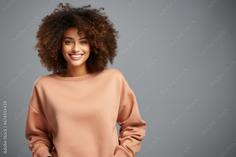 Happy beautiful young black woman posing wearing apricot sweatshirt against gray background. Copy space Happy beautiful young black woman posing wearing apricot sweatshirt against gray background. Copy space
