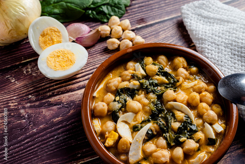 Delicious and traditional dish of chickpea stew with spinach and egg photo