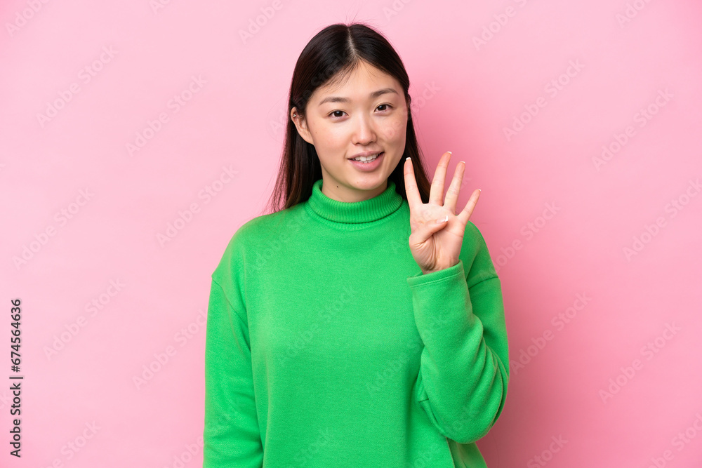 Young Chinese woman isolated on pink background happy and counting four with fingers Young Chinese woman isolated on pink background happy and counting four with fingers