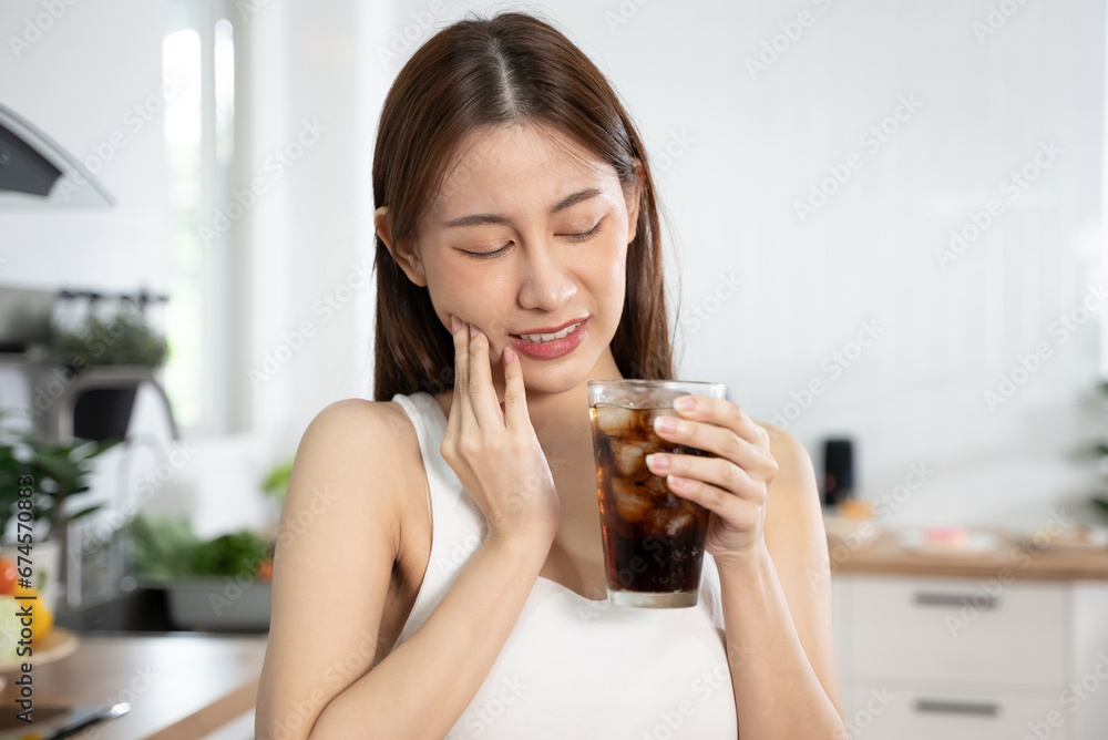 Person touch her cheek feeling sensitive teeth after drink cold soda Person touch her cheek feeling sensitive teeth after drink cold soda