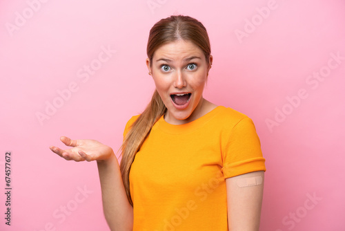 Wallpaper Mural Young caucasian woman wearing band aid isolated on pink background with shocked facial expression Torontodigital.ca