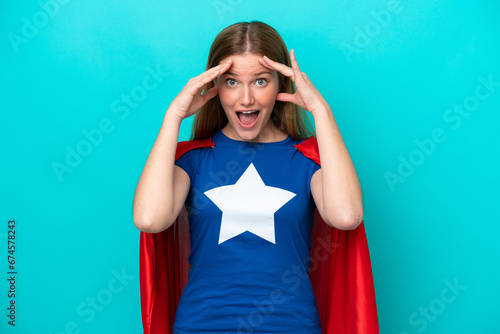Vászonkép Super Hero caucasian woman isolated on blue background with surprise expression