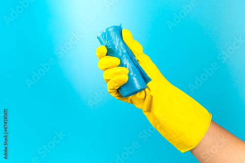 Woman's hands holding a garbage bag on a colored background. roll with plastic bags for garbage on background. Place for text. Garbage sorting.