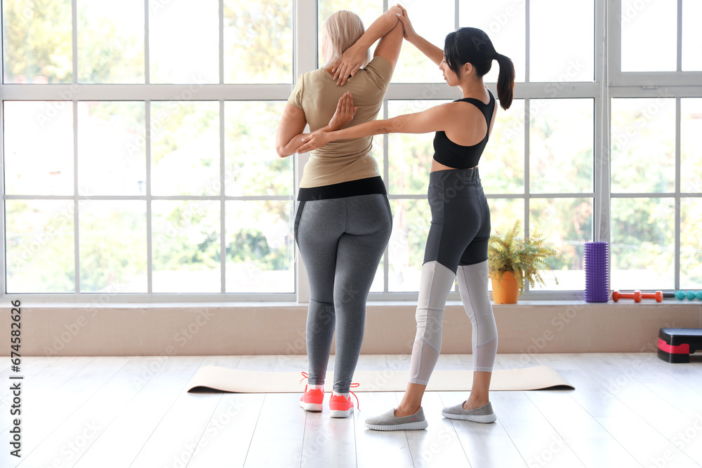Fototapeta premium Mature woman training with therapist in rehabilitation center
