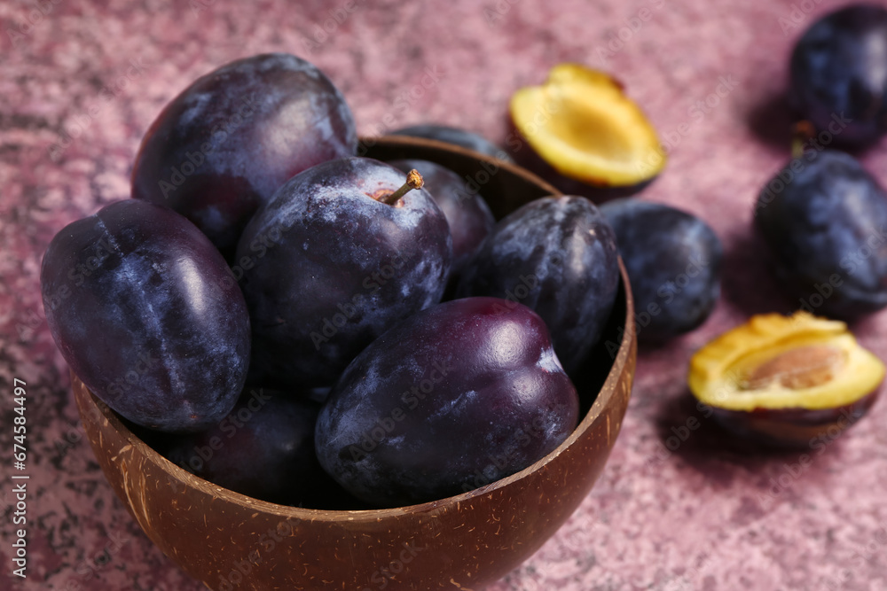 Bowl with fresh plums on purple background Bowl with fresh plums on purple background