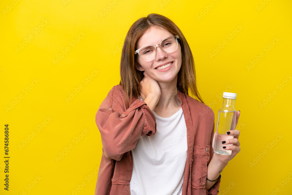 Young English woman with a bottle of water isolated on yellow background laughing Young English woman with a bottle of water isolated on yellow background laughing